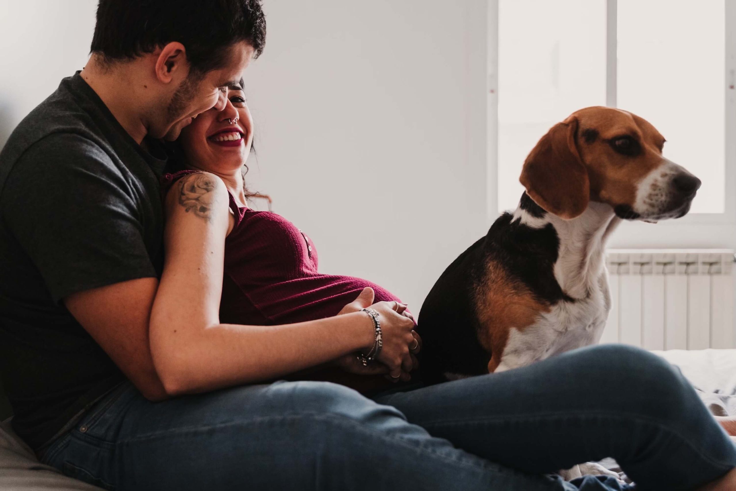 A pregnant couple and their dog