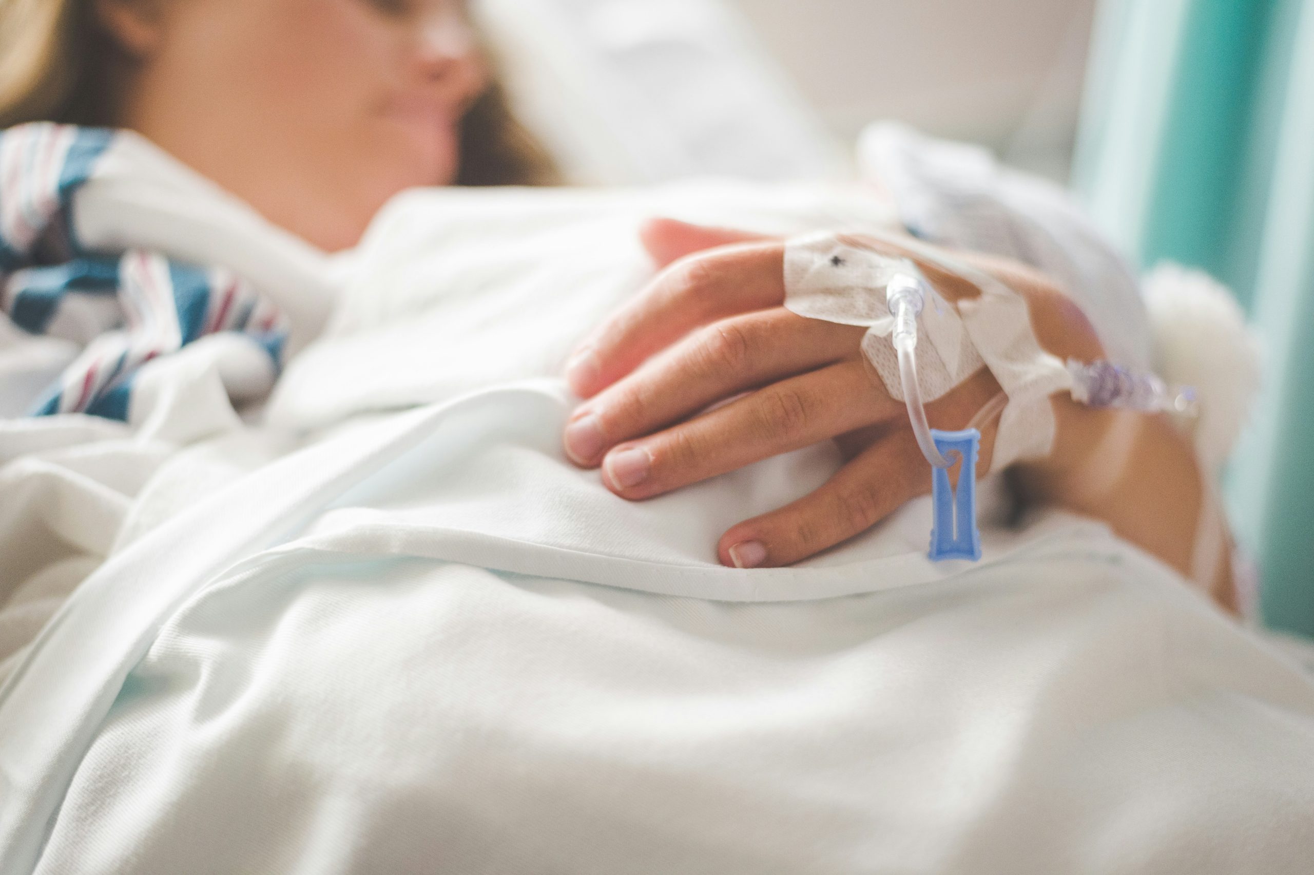 Woman holding baby with cannula in the back of her hand